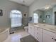 Bright bathroom featuring double windows, marble-top vanity, soaking tub and tile flooring at 2969 Wells Ave, North Port, FL 34286