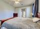 Comfortable bedroom with ceiling fan, wood furniture and a doorway leading to an ensuite bathroom at 2969 Wells Ave, North Port, FL 34286