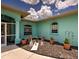 Charming front entrance with potted plants and garden decor accenting the turquoise exterior at 2969 Wells Ave, North Port, FL 34286