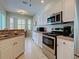 Bright kitchen with stainless steel appliances, white cabinets, and a cozy breakfast nook with bay windows at 2969 Wells Ave, North Port, FL 34286