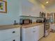 Modern kitchen with white cabinets, stainless steel appliances, and neutral countertops with ample counter space at 2969 Wells Ave, North Port, FL 34286