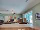 Airy living room with ceiling fan, television, and sliding glass door leading to an outdoor patio at 2969 Wells Ave, North Port, FL 34286