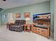 Comfortable living room featuring a plaid sofa, wooden accents, and a large flatscreen television at 2969 Wells Ave, North Port, FL 34286