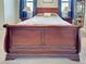 Elegant main bedroom showcasing a sleigh bed with wood frame, side tables, and tranquil ambiance at 2969 Wells Ave, North Port, FL 34286