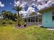 Backyard view of the home's screened in lanai and view of tropical landscaping at 2969 Wells Ave, North Port, FL 34286