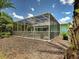 A rear view of the screened in lanai and pool and mulched landscaping at 2969 Wells Ave, North Port, FL 34286