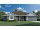 Charming one-story home showcasing a well-manicured lawn, gray exterior, and attached garage at 3984 Junction St, North Port, FL 34288
