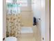 A tiled bathroom with tub and seashell-themed shower curtain at 421 Marsh Creek Rd, Venice, FL 34292