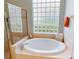 This bathroom features a luxurious soaking tub and privacy glass block window at 421 Marsh Creek Rd, Venice, FL 34292