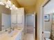 Bathroom featuring double vanity, large mirror and an entry to the bedroom at 421 Marsh Creek Rd, Venice, FL 34292