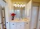 Bathroom featuring double vanity, large mirror and floral decor at 421 Marsh Creek Rd, Venice, FL 34292