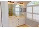 Bright bathroom featuring double sinks, shutters, and attractive light fixtures at 421 Marsh Creek Rd, Venice, FL 34292