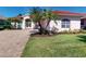 Beautiful home with a well-manicured lawn, lush landscaping, and a brick-paved driveway at 421 Marsh Creek Rd, Venice, FL 34292