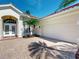 Lovely home exterior showcases a paved driveway leading to a garage and double-door entrance at 421 Marsh Creek Rd, Venice, FL 34292