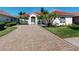 Charming home featuring a well-manicured front yard, brick driveway, and a tile roof at 421 Marsh Creek Rd, Venice, FL 34292