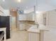 Well-lit kitchen with white cabinets, neutral countertops, stainless steel appliances, and tile flooring at 421 Marsh Creek Rd, Venice, FL 34292