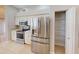 Bright kitchen with stainless steel refrigerator, oven, microwave, and storage space at 421 Marsh Creek Rd, Venice, FL 34292