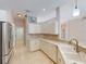 Kitchen featuring white cabinets, stainless appliances, and breakfast bar connecting to the adjacent room at 421 Marsh Creek Rd, Venice, FL 34292