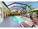 Relaxing screened-in pool area with comfortable lounge chairs and lush landscaping at 421 Marsh Creek Rd, Venice, FL 34292