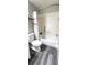 Bright bathroom featuring a tub with shower, white toilet, and wood-look flooring at 426 Ricold Ter, Port Charlotte, FL 33954