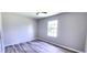 Cozy bedroom showcasing wood-look floors and a window for plenty of natural light at 426 Ricold Ter, Port Charlotte, FL 33954