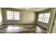 Open Living Room features wood-look floors and two large windows for lots of natural light at 426 Ricold Ter, Port Charlotte, FL 33954