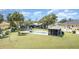 A backyard featuring a screened in gazebo and a rectangular pool surrounded by luscious grass and palms at 4460 Northshore Dr, Punta Gorda, FL 33980
