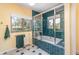 Bathroom featuring a tub with glass doors surrounded by teal tiles and windows with views of trees outside at 4460 Northshore Dr, Punta Gorda, FL 33980