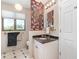 Bathroom with a white vanity with dark countertop and a decorative wood carving on the wall, with neutral paint at 4460 Northshore Dr, Punta Gorda, FL 33980
