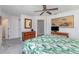 A bedroom featuring a leafy bedspread, dresser with mirror, and a television on a desk in a neutral-toned setting at 4460 Northshore Dr, Punta Gorda, FL 33980
