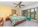 Bright bedroom featuring a decorative wood bed frame, ceiling fan, and a large window with backyard views at 4460 Northshore Dr, Punta Gorda, FL 33980