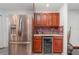Kitchen features a stainless steel refrigerator and wine cooler below cherry cabinets and red mosaic tile backsplash at 4460 Northshore Dr, Punta Gorda, FL 33980