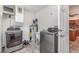 A laundry room featuring modern washer and dryer, water heater and an open doorway to the kitchen at 4460 Northshore Dr, Punta Gorda, FL 33980