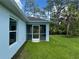 Corner view of the home's exterior and backyard showcasing its screened-in back patio at 8530 Sawyer Cir, North Port, FL 34288