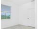 Bright bedroom featuring a window with blinds and a white door, offering a simple and serene living space at 8706 Seasalt Loop, Englewood, FL 34224