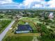 The house is in a green setting with a pool and shed, all enclosed in a fence, and nestled in a quiet Cape Coral neighborhood at 9954 Audrey St, Port Charlotte, FL 33981