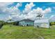 Expansive backyard with lush green grass, a screened lanai, and a shed, all enclosed within a secure black fence at 9954 Audrey St, Port Charlotte, FL 33981