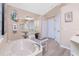 Well-lit bathroom offering wood floors, a tub, a vanity, a bench, and ample cabinet space at 9954 Audrey St, Port Charlotte, FL 33981