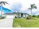 Charming home with a well-manicured lawn, an attached two car garage, and beautiful landscaping at 9954 Audrey St, Port Charlotte, FL 33981
