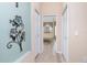 Hallway leading to the en-suite bathroom featuring wood floors and decorative wall art at 9954 Audrey St, Port Charlotte, FL 33981