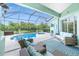 Relaxing screened lanai with plush seating, a ceiling fan, and direct access to the pool at 9954 Audrey St, Port Charlotte, FL 33981