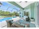 Comfortable lanai with stylish seating, ceiling fan, and views of the pool and garden at 9954 Audrey St, Port Charlotte, FL 33981