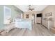 Spacious main bedroom with a large bed, a ceiling fan, wood floors, and a walk through to an en-suite bathroom at 9954 Audrey St, Port Charlotte, FL 33981