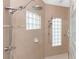 Walk-in shower featuring tile walls, glass block windows, and a double shower head system at 9954 Audrey St, Port Charlotte, FL 33981