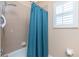 Shower featuring blue shower curtain and a white shuttered window at 9954 Audrey St, Port Charlotte, FL 33981