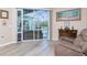 Light and airy sitting area featuring wood floors, a recliner, and sliding glass doors opening to the outside pool area at 9954 Audrey St, Port Charlotte, FL 33981