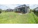 View of the backyard with a screened in lanai that includes a hot tub and outdoor furniture at 11383 Burgundy Dr, Venice, FL 34293