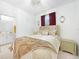 Bright bedroom features tile flooring, a chandelier, and tufted headboard at 11383 Burgundy Dr, Venice, FL 34293