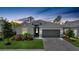 Inviting home with a gray driveway, manicured lawn, decorative plants, and a traditional architectural style at 11383 Burgundy Dr, Venice, FL 34293