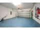 View of the spacious two car garage with blue epoxy flooring, overhead storage, and garage door opener at 11383 Burgundy Dr, Venice, FL 34293